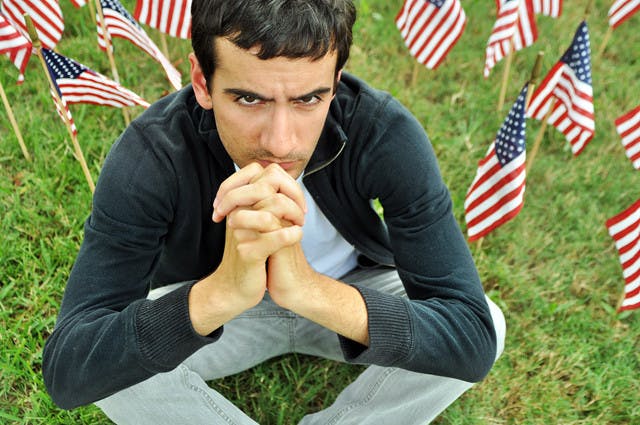 UF English senior Thomas Panevino, 21, who lived one block from the World Trade Center at the time of the 9/11 attacks, sits among the flags of the 9/11: Never Forget Project on the Reitz Union North Lawn.