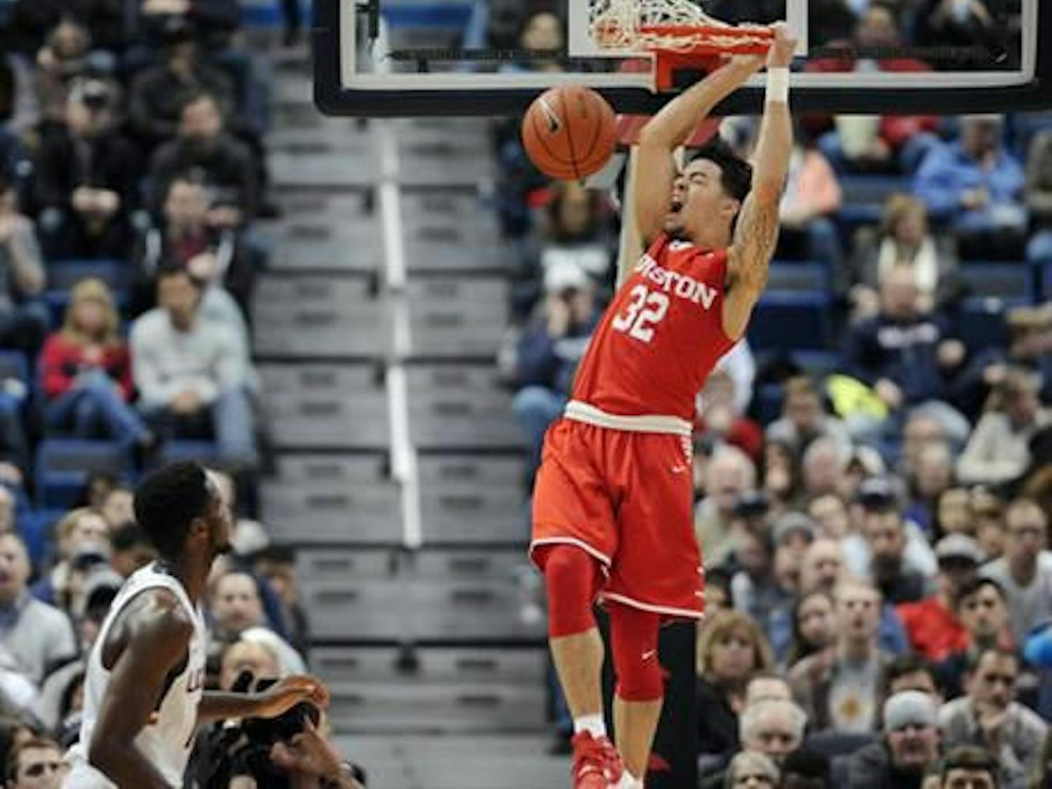 Houston's Rob Gray reacts while dunking the ball as Connecticut's Kentan Facey, left, looks on, in the first half of an NCAA college basketball game, Wednesday, Dec. 28, 2016, in Hartford, Conn. (AP Photo/Jessica Hill)