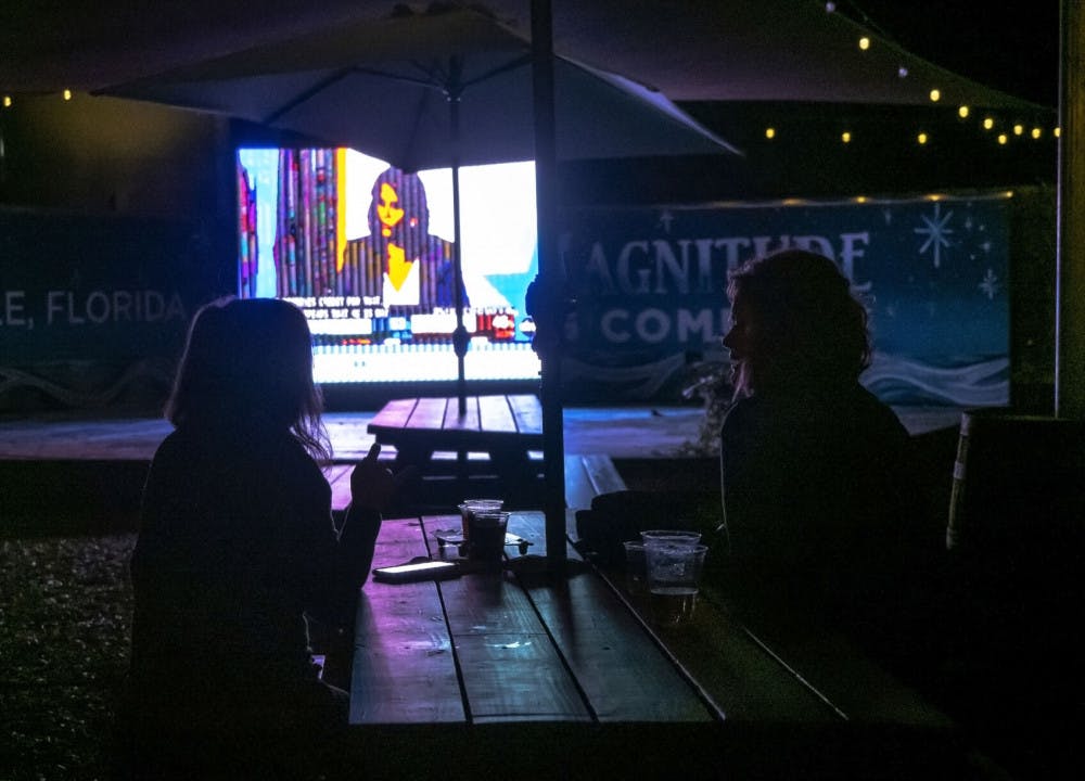 Two women watch the presidential election results at First Magnitude Brewery, located in Gainesville, Fla., on Tuesday, Nov. 3, 2020. (Emily Felts/Alligator Staff)