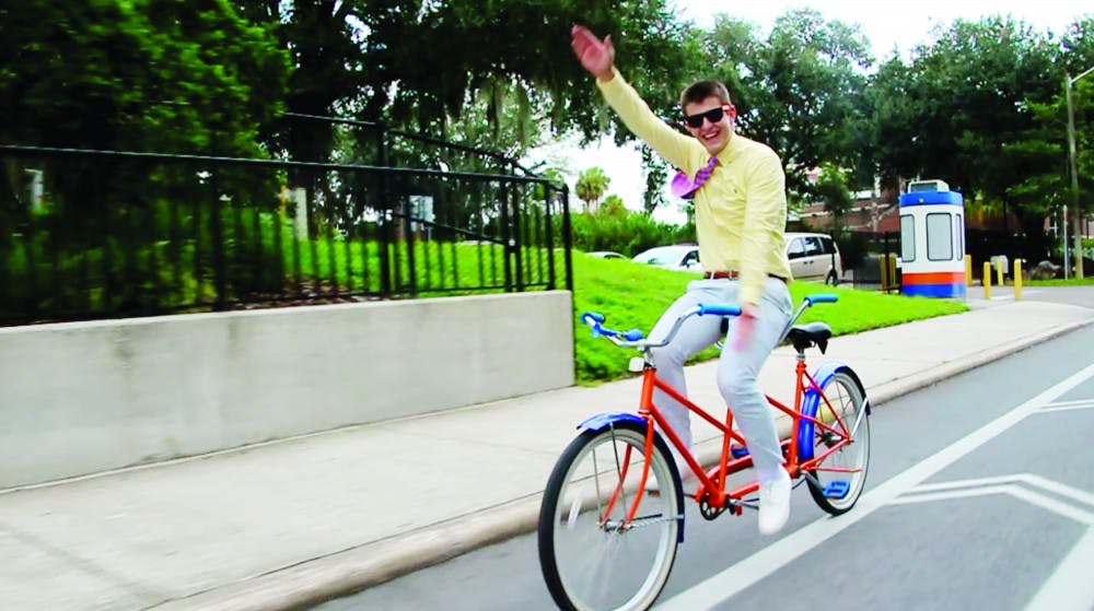 Michael Cizek, a 19-year-old UF finance sophomore, Gator Chomps while bicycling down Stadium Road. He was chosen by the University Athletic Association as the winner of this year’s Mr. Two Bits competition Monday.