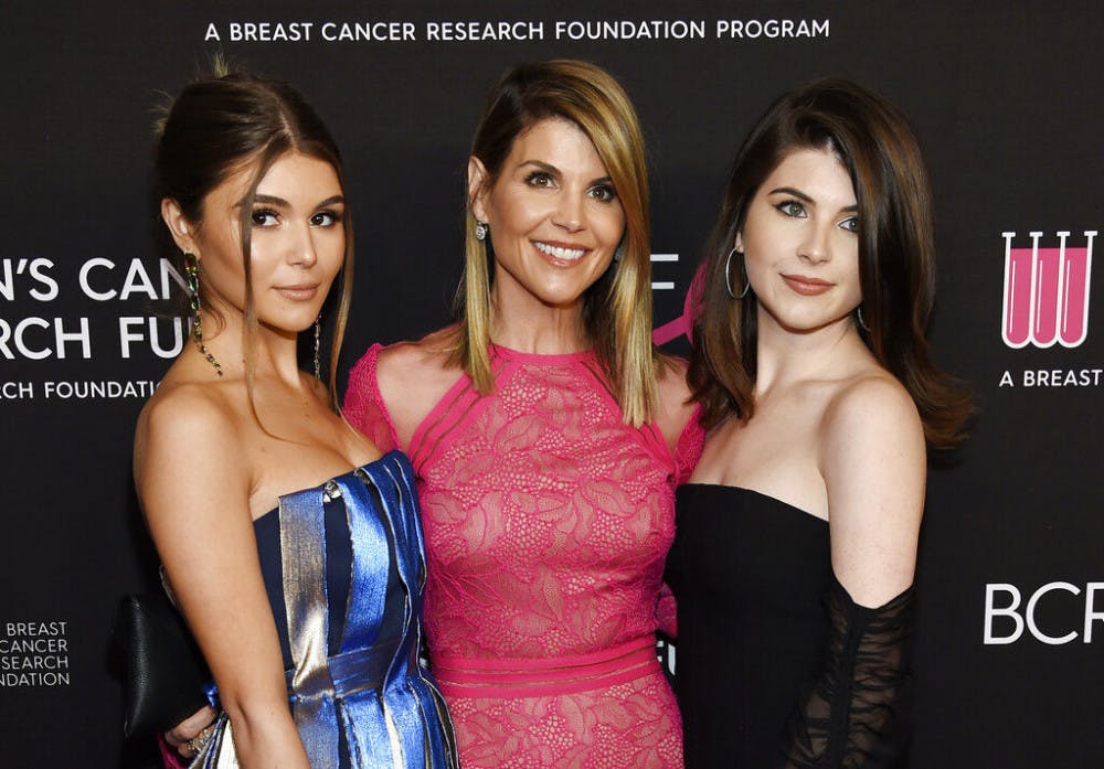 FILE - In this Feb. 28, 2019 file photo, actress Lori Loughlin, center, poses with daughters Olivia Jade Giannulli, left, and Isabella Rose Giannulli at the 2019 "An Unforgettable Evening" in Beverly Hills, Calif. Loughlin and her husband Mossimo Giannulli were charged along with nearly 50 other people Tuesday in a scheme in which wealthy parents bribed college coaches and other insiders to get their children into some of the most elite schools in the country, federal prosecutors said. (Photo by Chris Pizzello/Invision/AP, File)