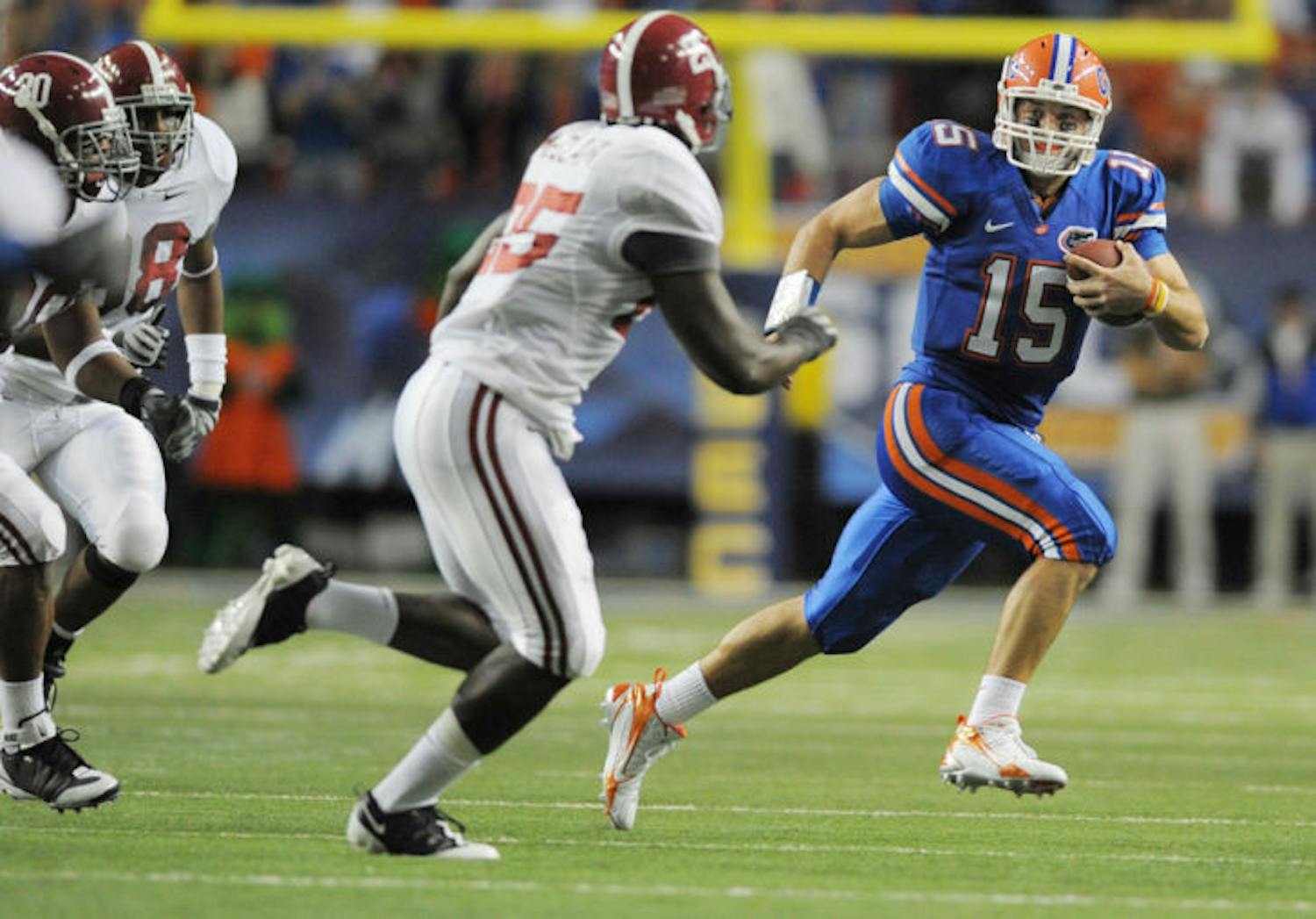 Former Florida quarterback Tim Tebow (15) escapes pressure from Alabama linebacker Rolando McClain (25) during UF&#x27;s 31-20 win in the 2008 SEC Championship Game. Tebow signed with the Jaguars as a tight end May 20.