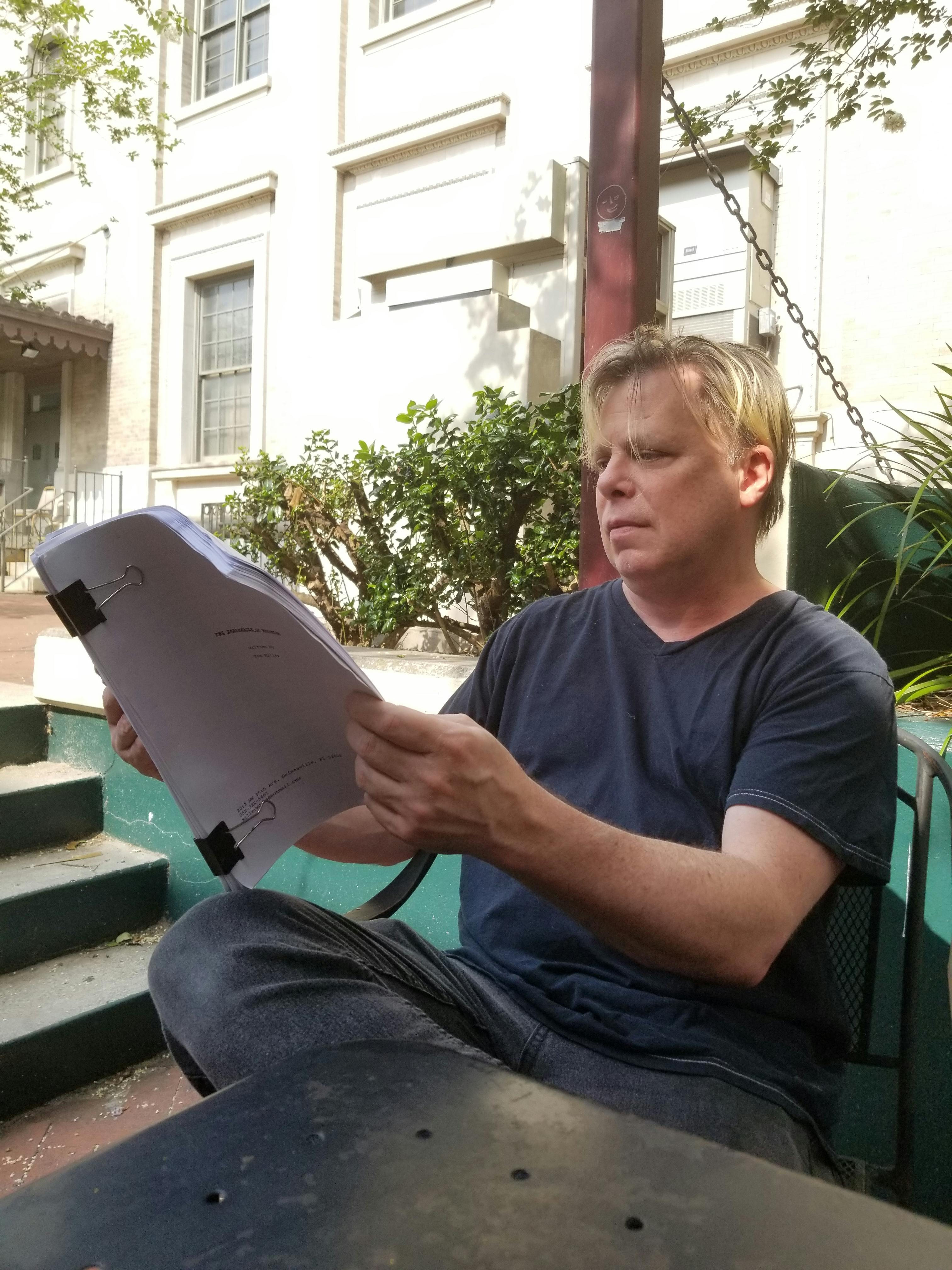 Writer and Gainesville resident Tom Miller looks over his most recent work "The Tabernacle Hedonism."