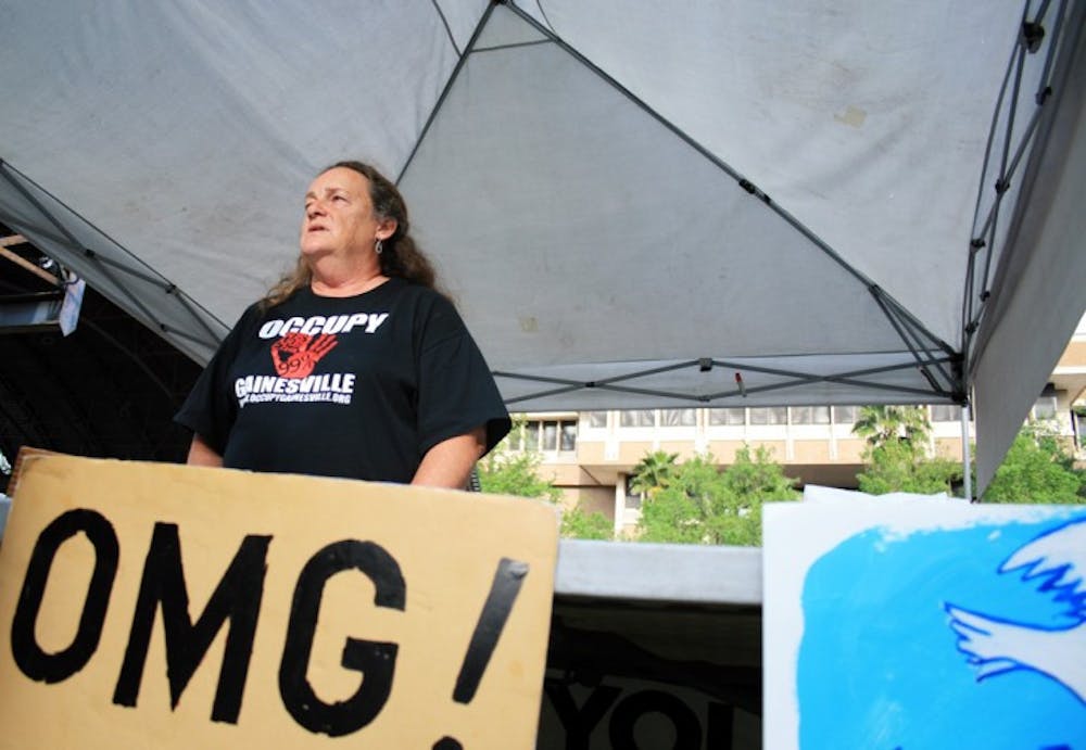 <p>Occupy supporter Annette Gilley, 58, of Waldo, talks with activists in Bo Diddley Community Plaza on Wednesday afternoon during the Union Street Farmers Market. Supporters have occupied the downtown plaza since Oct. 12.</p>