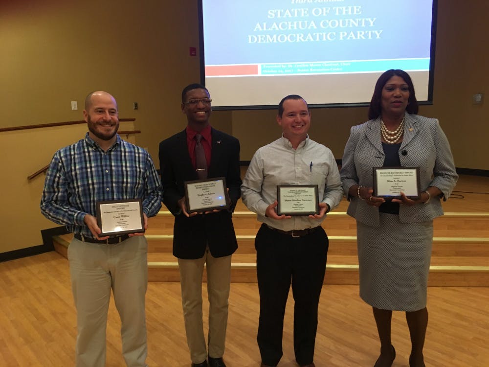 <p><span id="docs-internal-guid-e43aae6e-51bb-8f82-7804-0dc7288eaefb"><span>From left: Alachua County resident Casey Willits, who won the Sally Guthrie Award for volunteer work with voter outreach; UF political science freshman Stephon Adams, who won the Young Democrats Jeffrey Wershow Award; supervisor of elections Kim Barton, who won the Eleanor Roosevelt Award; and Hawthorne Mayor Matthew Surrency, who won the Harry S. Truman “The Buck Stops Here” Award, pose with their plaques.</span></span></p>