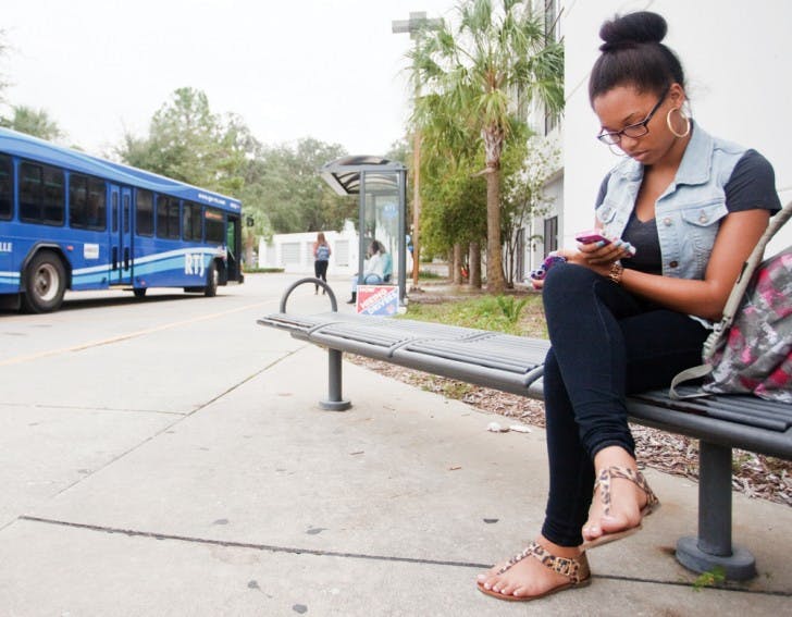 Whitney Jeter, a 19-year-old health sciences sophomore, waits to take the No. 23 bus home after her Marriage and Family class at Sante Fe College on Tuesday afternoon.