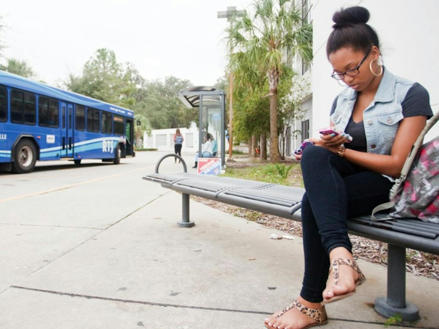 Whitney Jeter, a 19-year-old health sciences sophomore, waits to take the No. 23 bus home after her Marriage and Family class at Sante Fe College on Tuesday afternoon.