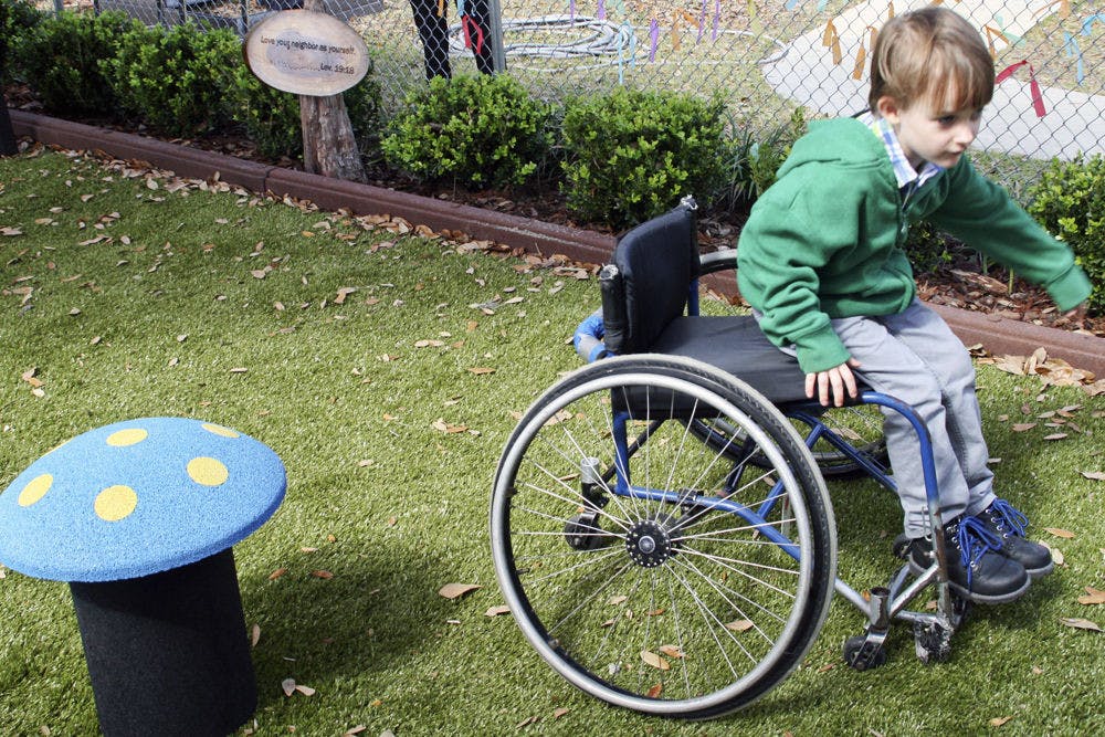 <p>Ryan, 6, rides a wheelchair in the Trinity United Methodist Church playground Sunday afternoon. Though he was not disabled himself, the wheelchair allowed Ryan to test the park’s accessibility for wheelchair users.</p>