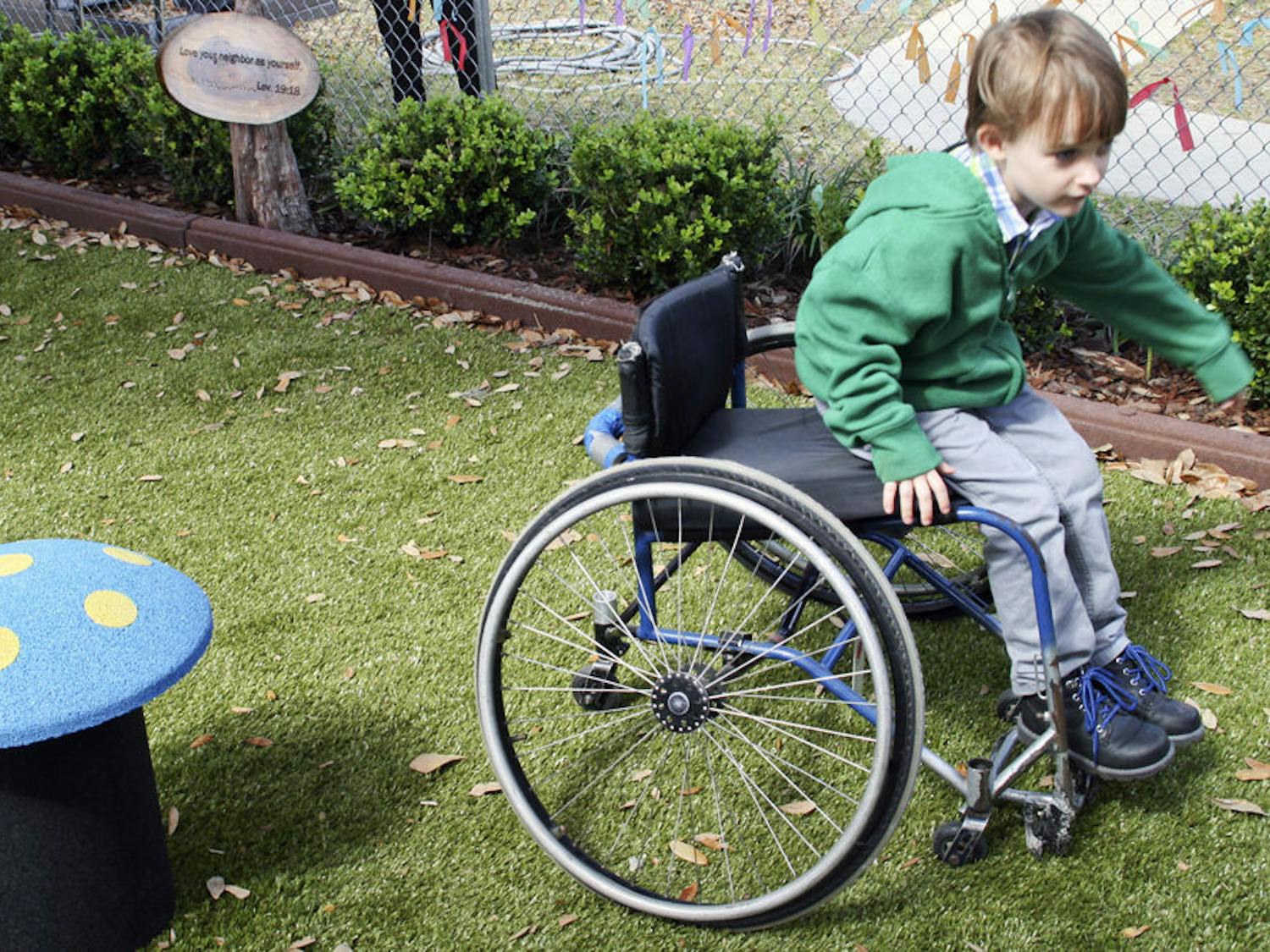 Ryan, 6, rides a wheelchair in the Trinity United Methodist Church playground Sunday afternoon. Though he was not disabled himself, the wheelchair allowed Ryan to test the park’s accessibility for wheelchair users.
