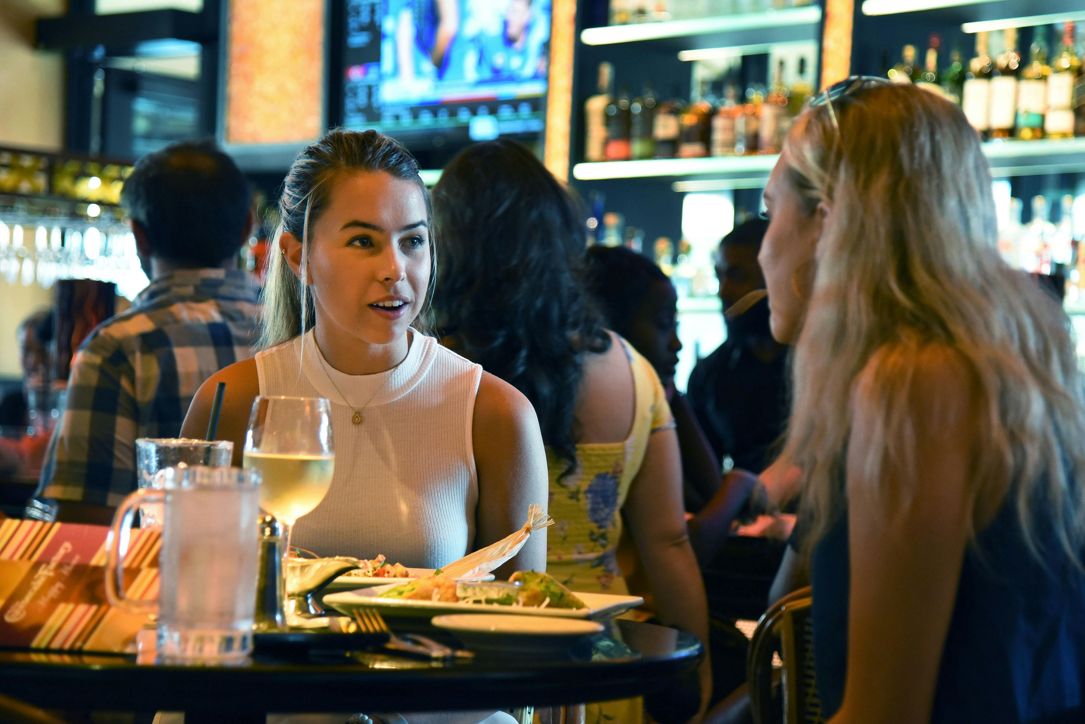 Jordan Kovacs, a 21-year-old UF health science student eats dinner with Sophie Franklin, a 21-year-old UF biology student, at the Cheesecake Factory grand opening Tuesday night. About 150 people came to the opening, some waiting in line for up to two and a half hours to be seated. “I’ve been going back to the one at home for 10 years,” Kovacs said about the restaurant chain. “Of course I’m here for the opening night.”