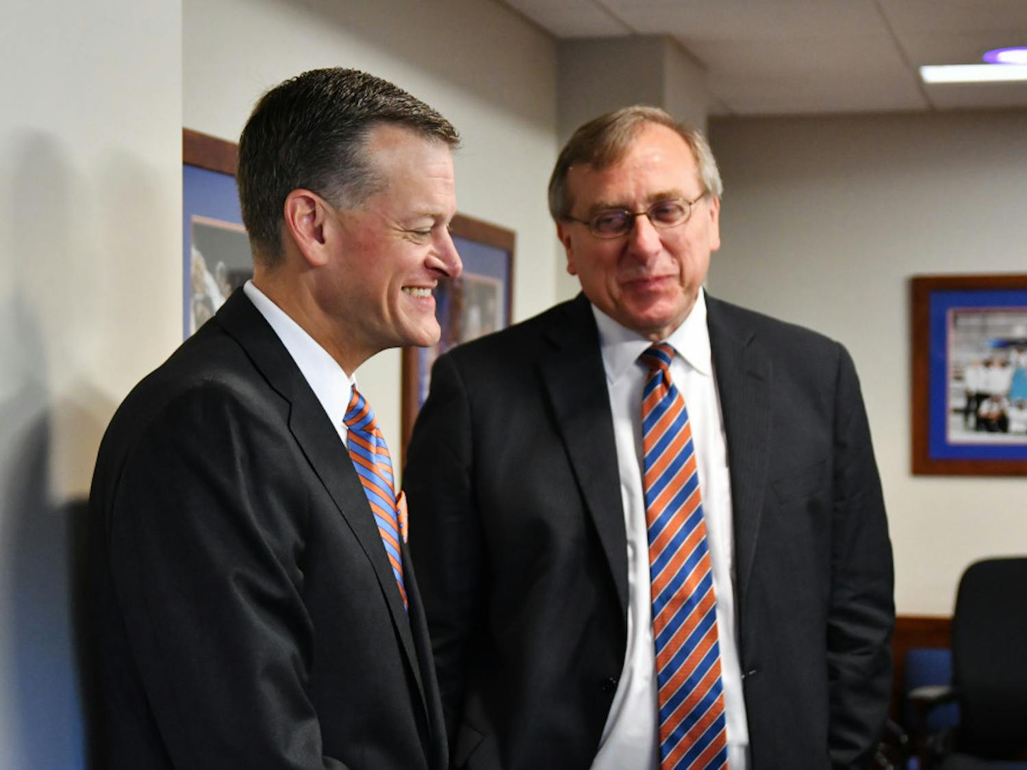Scott Stricklin, UF's new athletic director, speaks with UF president Kent Fuchs during a UAA board meeting. Stricklin, who has worked as Mississippi State University's athletic director since 2010, was unanimously approved Tuesday morning. 