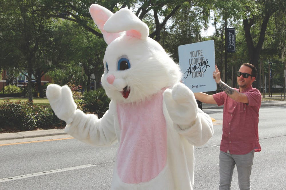 <p dir="ltr"><span>The Easter Bunny and Charles Young, pastor of Alive Church, located at 1826 W. University Ave., wave to passing drivers before heading inside for an evening service.</span></p><p><span> </span></p>