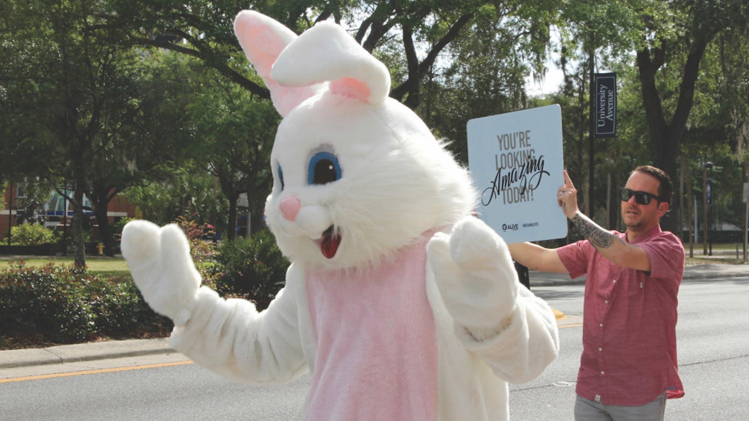 The Easter Bunny and Charles Young, pastor of Alive Church, located at 1826 W. University Ave., wave to passing drivers before heading inside for an evening service. 