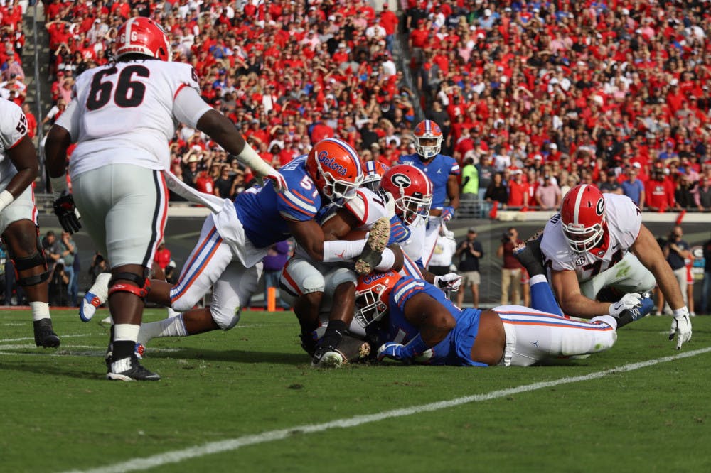 <p>Linebacker Ventrell Miller and his teammates tackle a Georgia ball carrier Nov. 7, 2020. Miller returns to UF this season after tearing his bicep last year.</p>