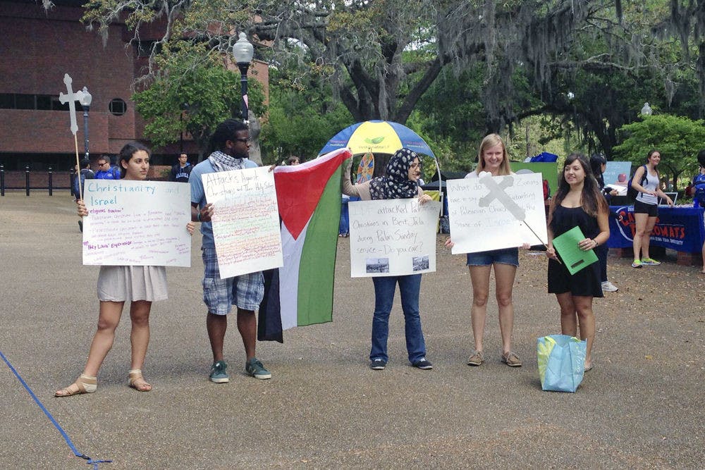 From left: Amanda Bateh, 19, Eric Brown, 21, Tesneem Shraiteh, 21, Amanda Nelson, 21, and Farah Khan, 21, speak on Turlington Plaza on Tuesday about discrimination that Palestinian Christians face as their Easter celebration approaches Sunday. “I feel like this is the least I can do, to be involved in this campus organization,” Bateh said, “because injustice happens every day in Palestine.”