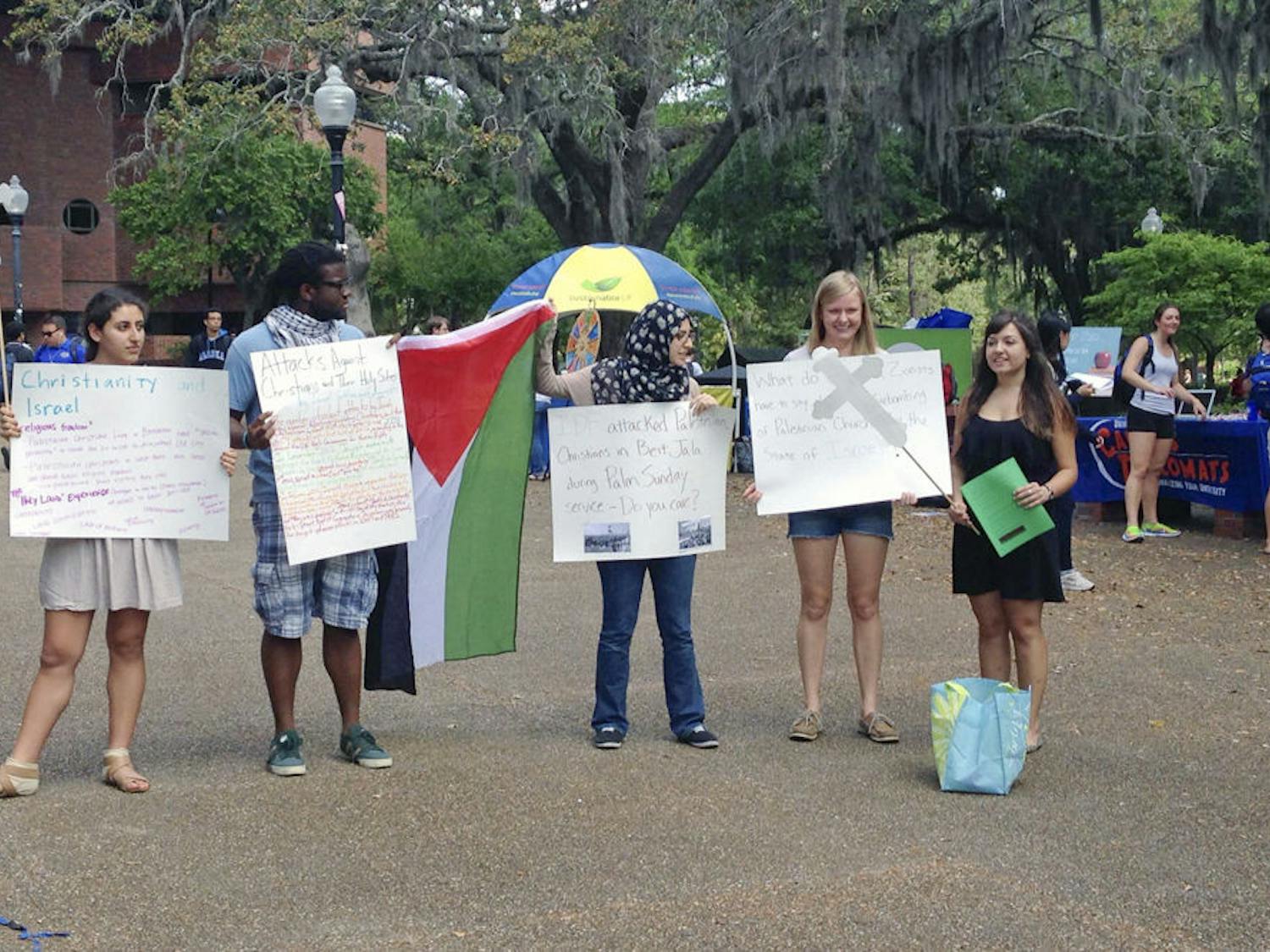 From left: Amanda Bateh, 19, Eric Brown, 21, Tesneem Shraiteh, 21, Amanda Nelson, 21, and Farah Khan, 21, speak on Turlington Plaza on Tuesday about discrimination that Palestinian Christians face as their Easter celebration approaches Sunday. “I feel like this is the least I can do, to be involved in this campus organization,” Bateh said, “because injustice happens every day in Palestine.”