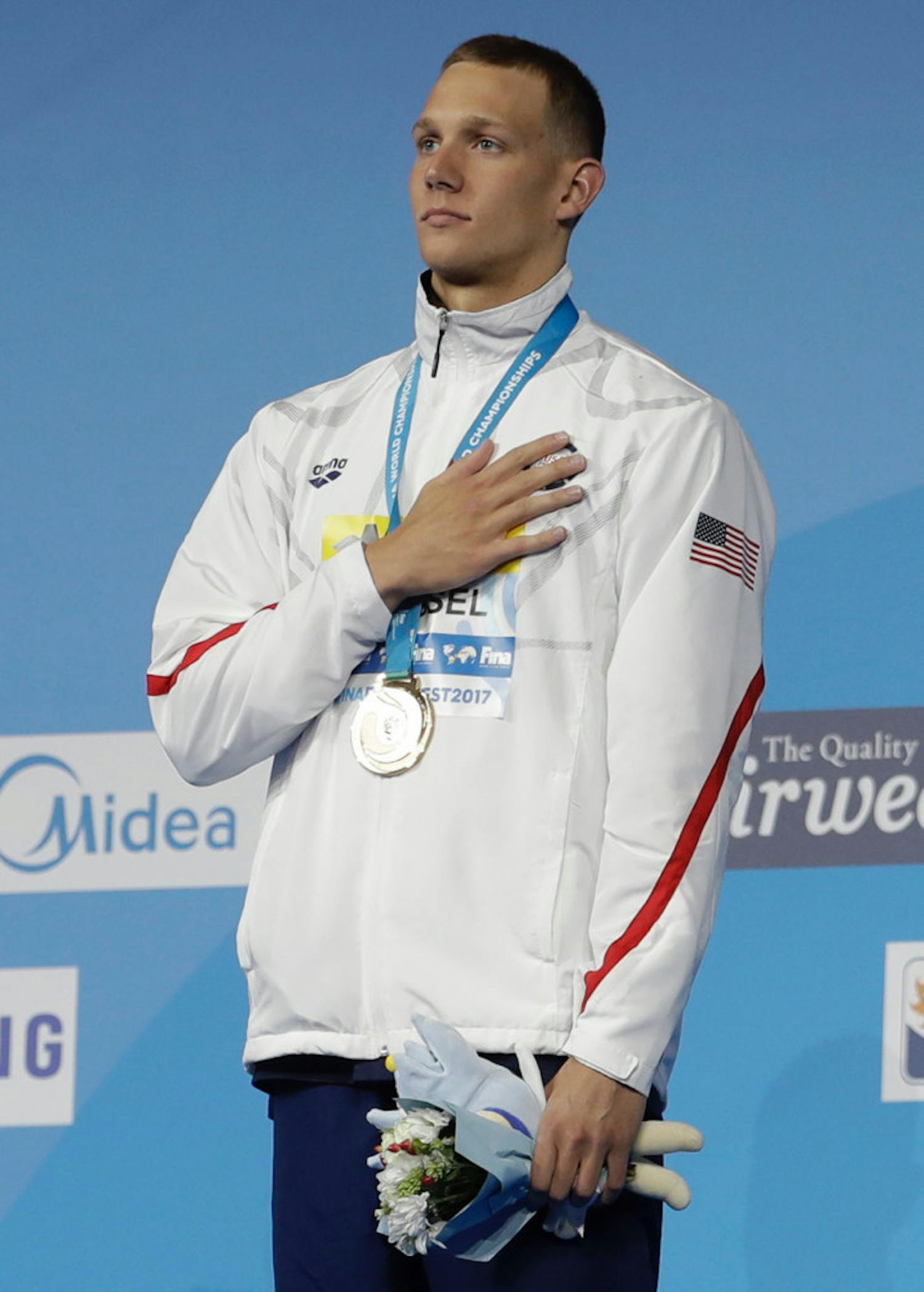 ASSOCIATED PRESS United States’ Caeleb Remel Dressel listens to the national anthem after winning the gold medal in the men’s 100-meter butterfly final during the swimming competitions of the World Aquatics Championships in Budapest, Hungary, on Saturday.