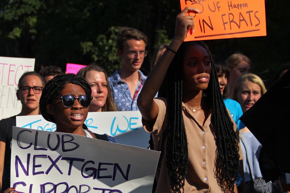 Yveline Saint Louis, a 19-year-old UF microbiology sophomore, and Torri McFarlane, a 19-year-old UF public relations sophomore, march down Fraternity Drive Tuesday afternoon during the protest for blue lights. 