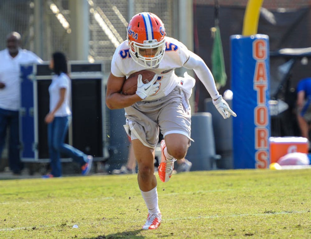 <p>Jalen Tabor carries the ball during Florida’s second open practice on March 21 at Sanders Practice Fields.</p>