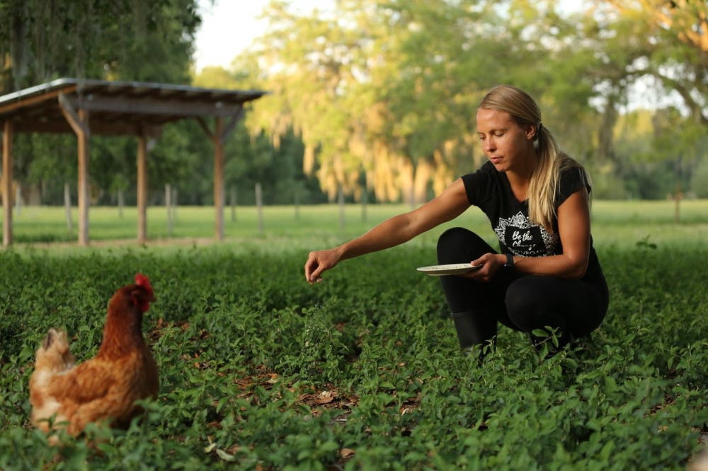 <p><span>Emma Hoel, co-founder of Peacefield, feeding Bernadette, one of the chickens living at Peacefield.</span></p>