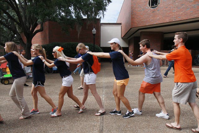Students form a conga line on Turlington Plaza on Wednesday afternoon as part of a flash mob to promote Gator Growl 2011.