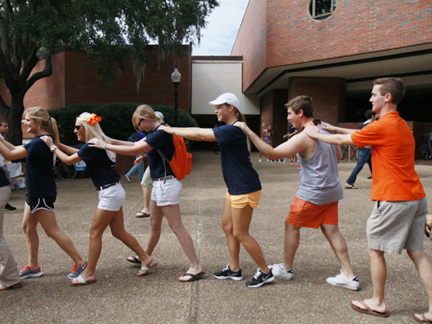 Students form a conga line on Turlington Plaza on Wednesday afternoon as part of a flash mob to promote Gator Growl 2011.