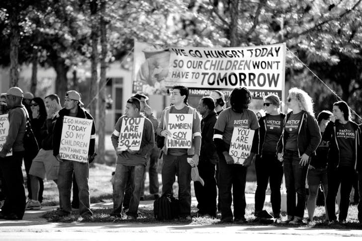 Victor Yengle, a 23-year-old economics junior, holds a sign that reads, "Yo Tambien Soy Humano" while fasting at a protest for fair wages for tomato pickers.