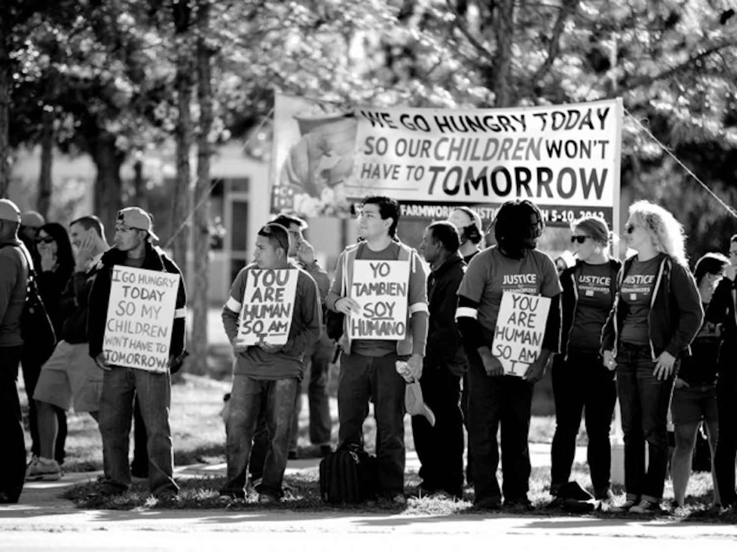 Victor Yengle, a 23-year-old economics junior, holds a sign that reads, "Yo Tambien Soy Humano" while fasting at a protest for fair wages for tomato pickers.