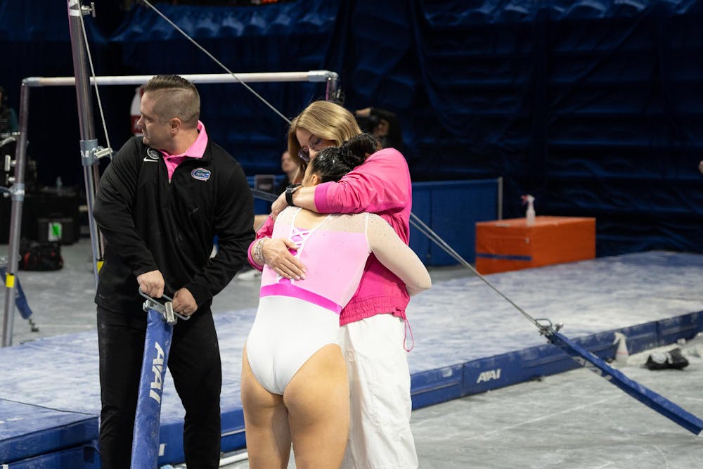 Florida gymnastics head coach Jenny Rowland hugs senior gymnast Ellie Lazzari after her performance on the uneven bars against Arkansas on Friday, Feb. 9, 2024.