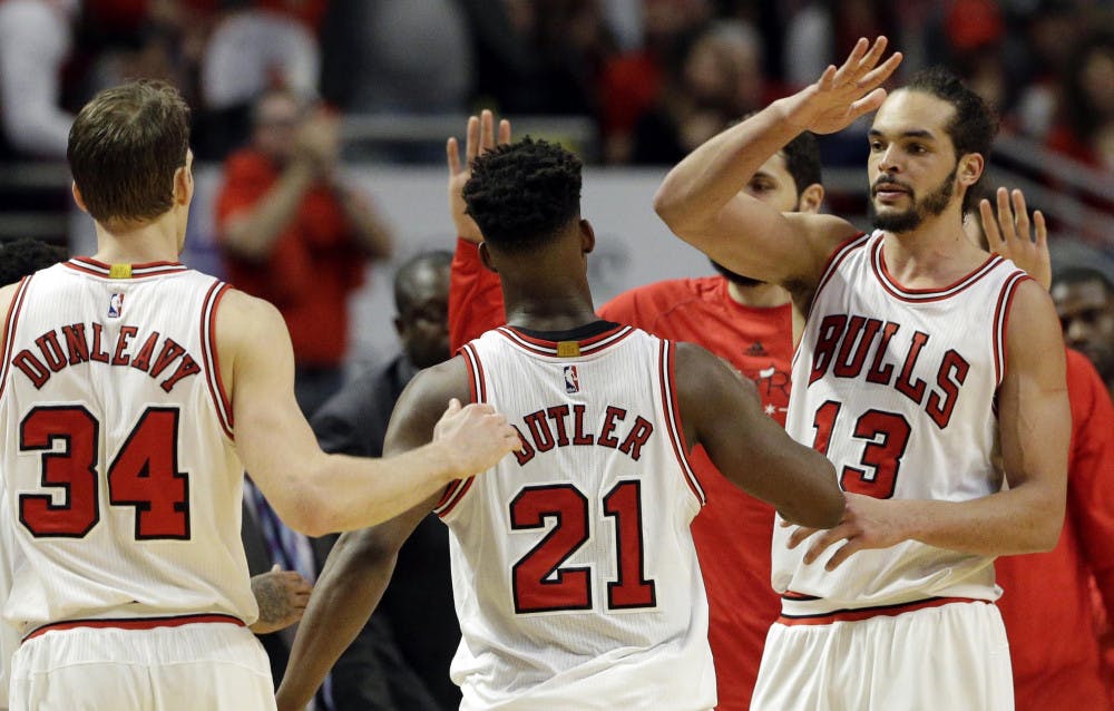 Chicago Bulls center Joakim Noah, right, celebrates with guard Jimmy Butler, center, and forward Mike Dunleavy after Butler scored a basket during the second half in Game 1 of the NBA basketball playoffs against the Milwaukee Bucks Saturday, April 18, 2015, in Chicago. The Bulls won 103-91.