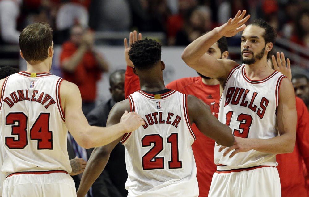 <p>Chicago Bulls center Joakim Noah, right, celebrates with guard Jimmy Butler, center, and forward Mike Dunleavy after Butler scored a basket during the second half in Game 1 of the NBA basketball playoffs against the Milwaukee Bucks Saturday, April 18, 2015, in Chicago. The Bulls won 103-91.</p>