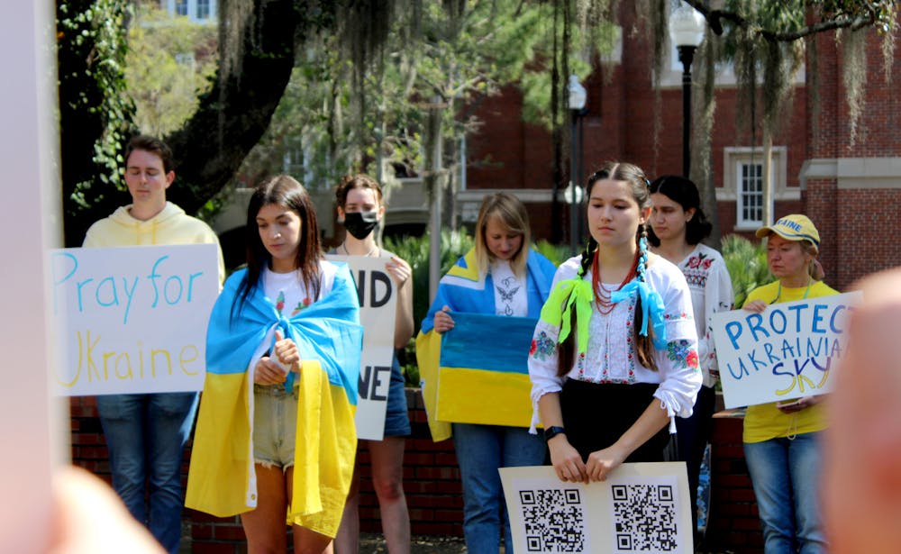 Roksolana Myktiuk, 25, a non-degree seeking UF women’s studies exchange student (left) and Sasha Nelson, 19, UF microbiology sophomore lead a group of about 30 in a minute of silence for the Ukrainian lives lost in their ongoing war with Russia on Thursday, March 3.