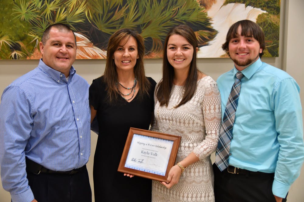 <p dir="ltr">From left: Robert Volk, Jennifer Volk, Kayla Volk and Travis Pemberton pose for a picture with Kayla Volk, a 21-year-old UF biology senior, who received the $1,500 scholarship.</p><p><span> </span></p>