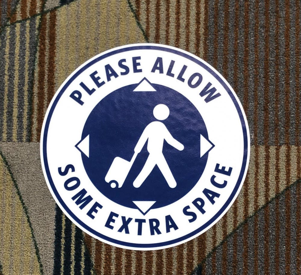 A stick on the floor of the Gainesville Regional Airport promoting social distancing.