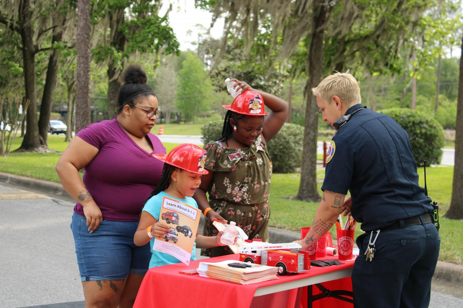 Autumn Anderson, 6, and Taylar Cook, 9, talk to firefighter Zoe Siemienskil at the Bike Rodeo, Safety and Health Fair hosted by UF Health Shands Children’s Hospital on Saturday, March 25, 2023.