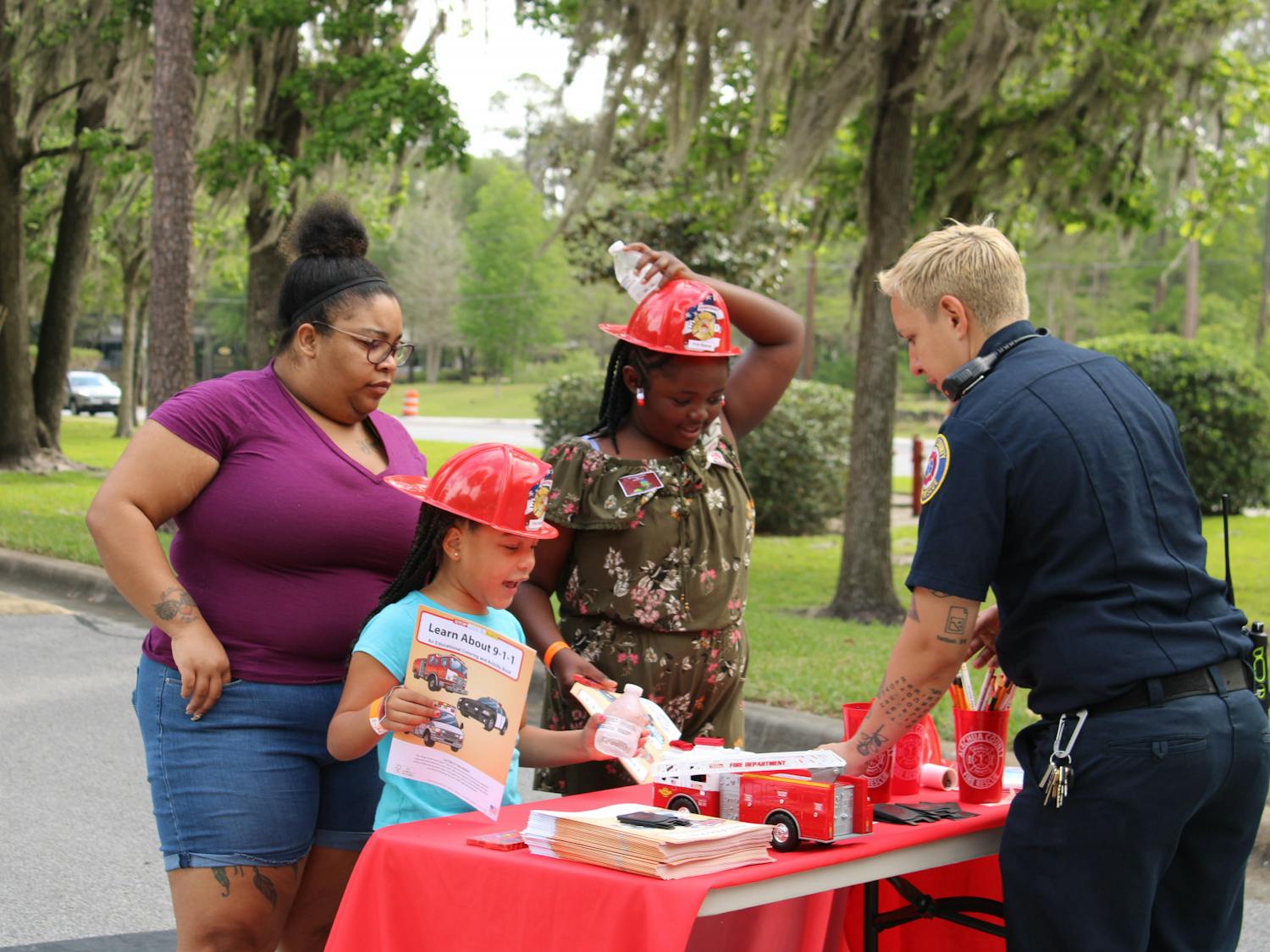 Autumn Anderson, 6, and Taylar Cook, 9, talk to firefighter Zoe Siemienskil at the Bike Rodeo, Safety and Health Fair hosted by UF Health Shands Children’s Hospital on Saturday, March 25, 2023.