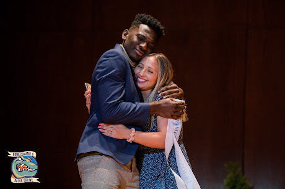 <p>Sydney Brandenburg, director of the homecoming, hugs Evan Curry, one of the homecoming court members.&nbsp;</p>