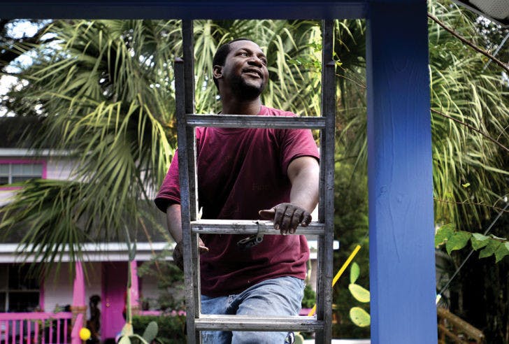 Gerard Duncan, local pastor and founder of the “Occupy My Streetz” initiative, finishes painting a Pleasant Street home Saturday in an effort to revitalize the community.