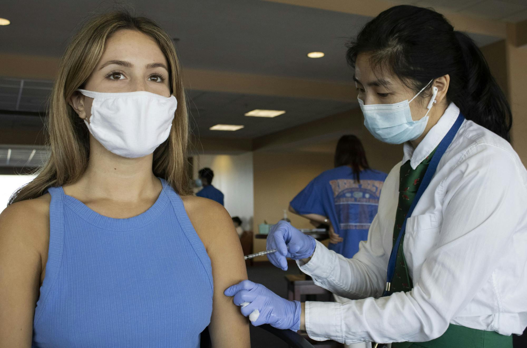 Isabel Crist, 19, (left) a UF telecommunication freshman, receives her first dose of the Pfizer-BioNTech COVID-19 vaccine on Monday, April 5, 2021. Monday was the first day COVID-19 vaccines were made widely available to UF students.