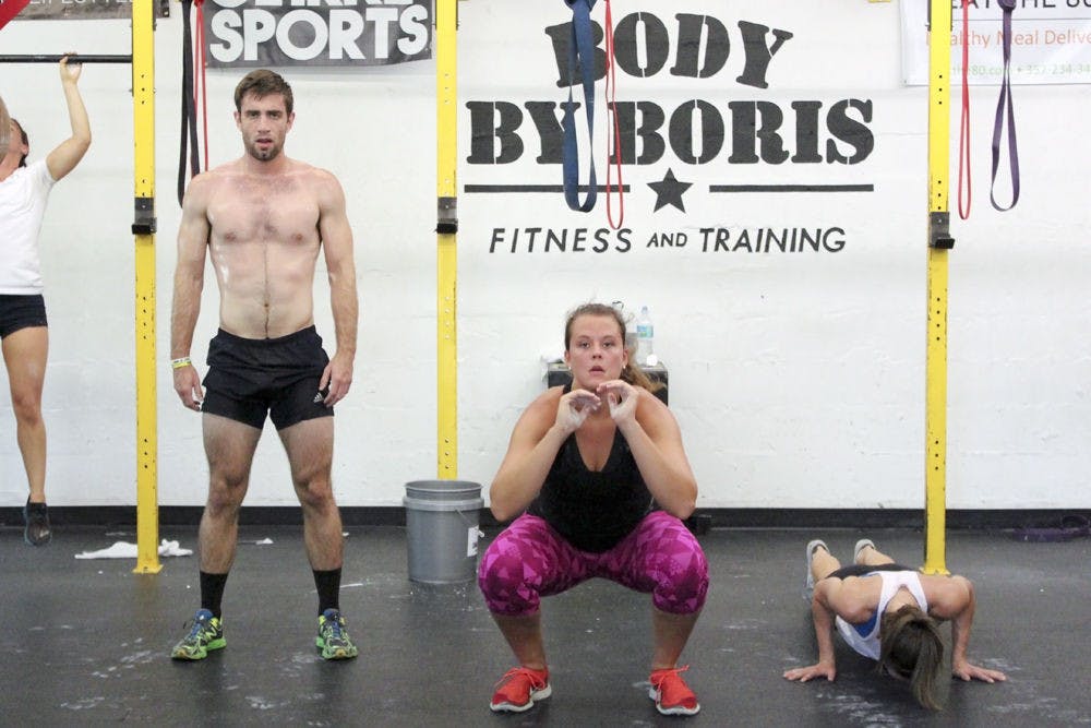 From left: Hunter Wyatt, 24, Samantha Mauder, 22, and Chloe Herring, 23, perform various exercises at the Memorial Day Murph event put on by Body By Boris, 1527 NW 6th St., on Monday. The event benefitted the Jonathan Cote Memorial Scholarships, which helps veteran UF and Santa Fe students pay for books and tuition.