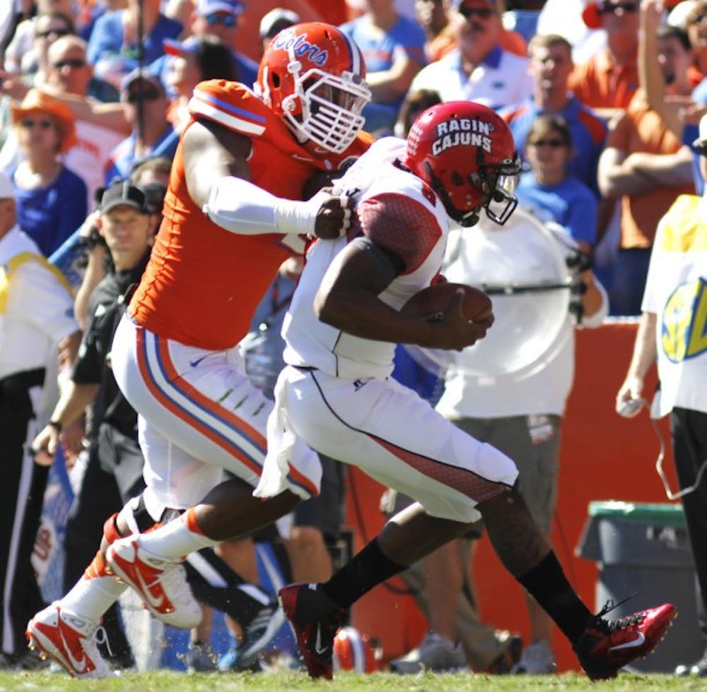 <p>Defensive lineman Dominique Easley tackles Louisiana quarterback Terrence Broadway during Florida's 27-20 win on Nov. 10&nbsp;in Ben Hill Griffin Stadium. Easley returned to practice Tuesday after missing Monday with the flu.</p>