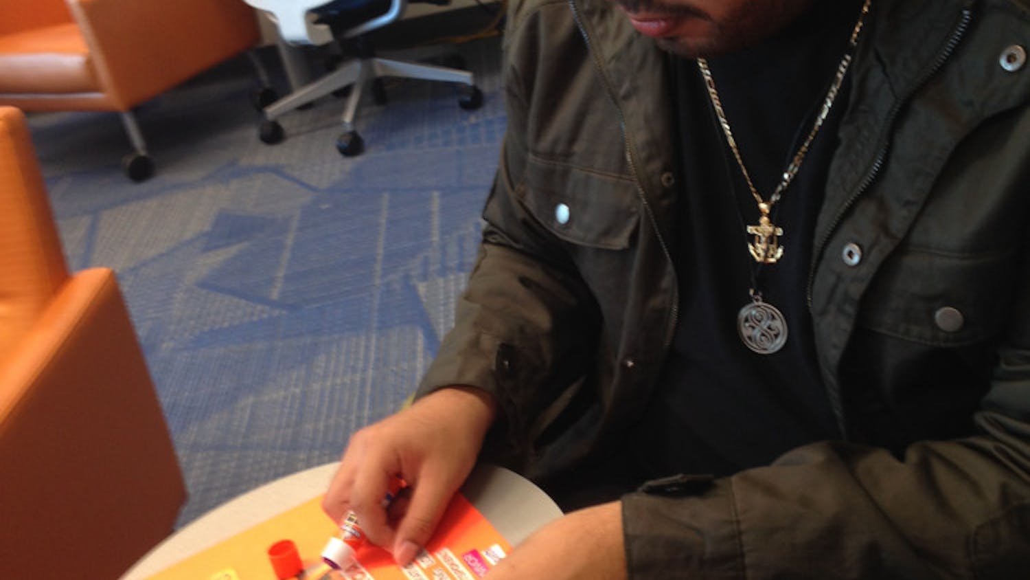 Cristian Laureano, a 20-year-old UF criminology senior, pastes cut-out magazine headlines onto a collage representing his New Year’s resolution to improve all aspects of his life. Laureano was participating in Multicultural and Diversity Affairs “Decolonizing New Year’s Resolutions” event on Monday from 2 p.m. to 4 p.m.