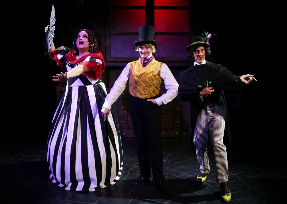 <p>Actors Matthew McGee, Kelly Atkins and David Patrick Ford take center stage in costume for their roles in the Hippodrome's "Scrooge in Rouge."</p>