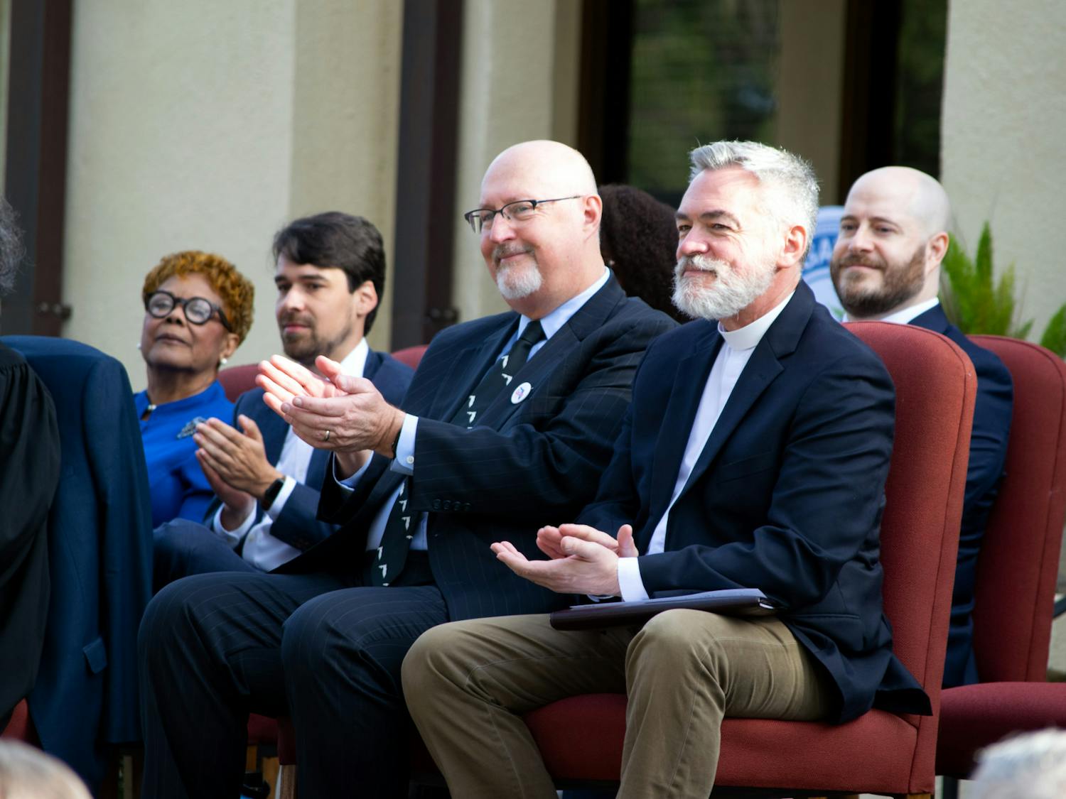 Harvey Ward (left) and Rev. Fletcher of Holy Trinity Episcopal Church (right) clapping after a speech delivered at the swearing-in ceremony for Gainesville Mayor Thursday, Jan. 5, 2023. 