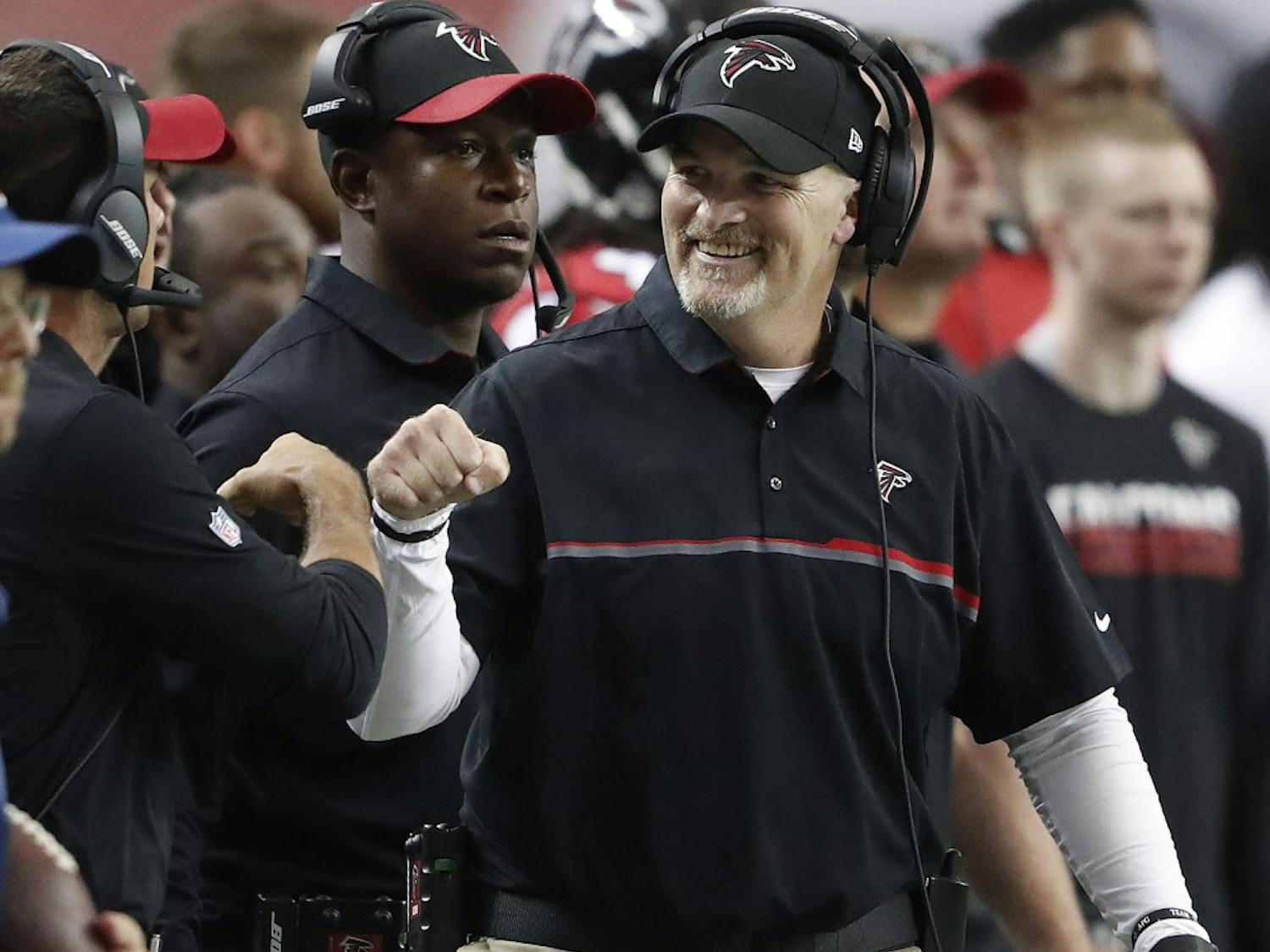 Atlanta Falcons head coach Dan Quinn fist bumps a coach after the Carolina Panthers were stopped during the first half of an NFL football game, Sunday, Oct. 2, 2016, in Atlanta. (AP Photo/John Bazemore)