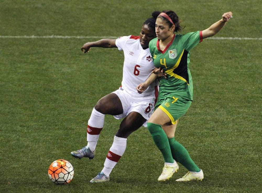 <p>Canada's Deanne Rose, left, fends off Guyana's Kayle De Souza during Olympic qualifying action Thursday. Rose scored two goals in a breakout performance. (PAT SULLIVAN / THE ASSOCIATED PRESS)</p>