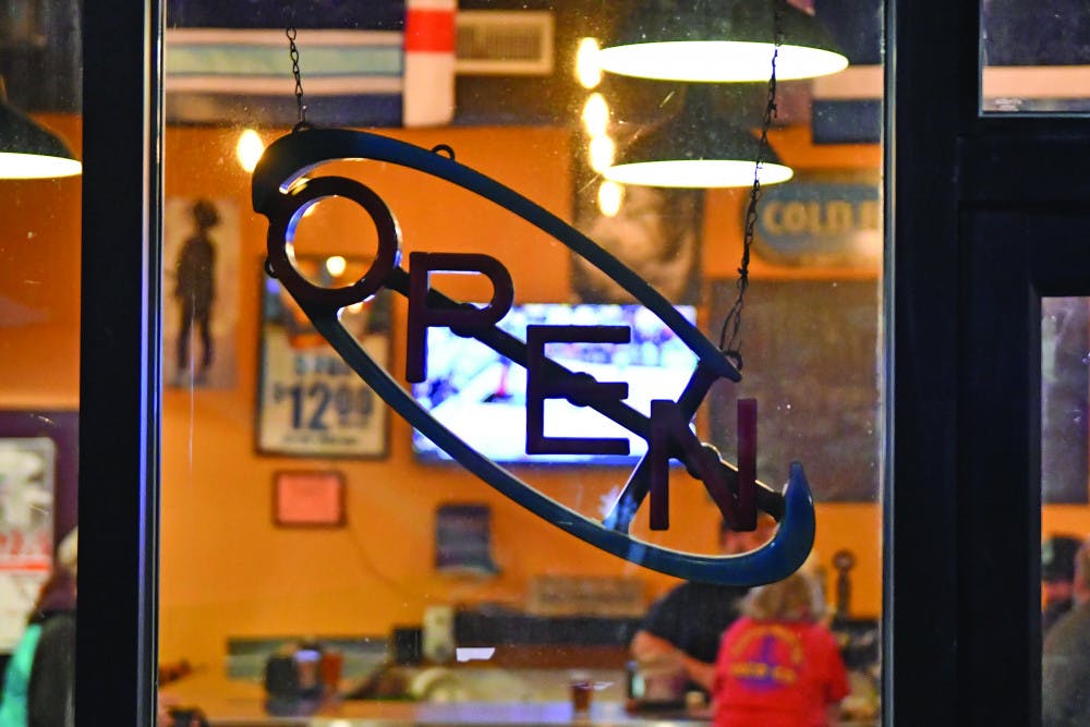 The “open” light is turned off as employees reminisce in the background about their time at Burrito Brothers Taco Co. Burrito Brothers shut down for good Saturday evening after running out of food around 6:30 p.m.