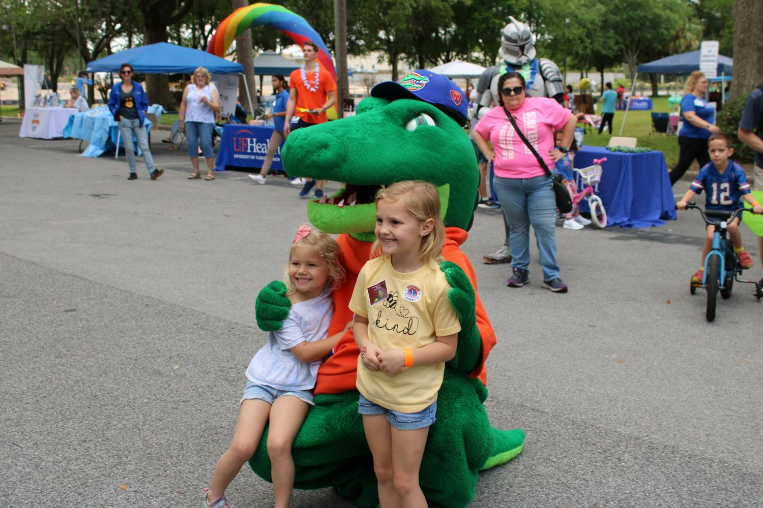 Sisters Hayden, 4, and Skylar, 6, pose for a picture with Albert and Alberta at the at the Bike Rodeo, Safety and Health Fair hosted by UF Health Shands Children’s Hospital on Saturday, March 25, 2023.