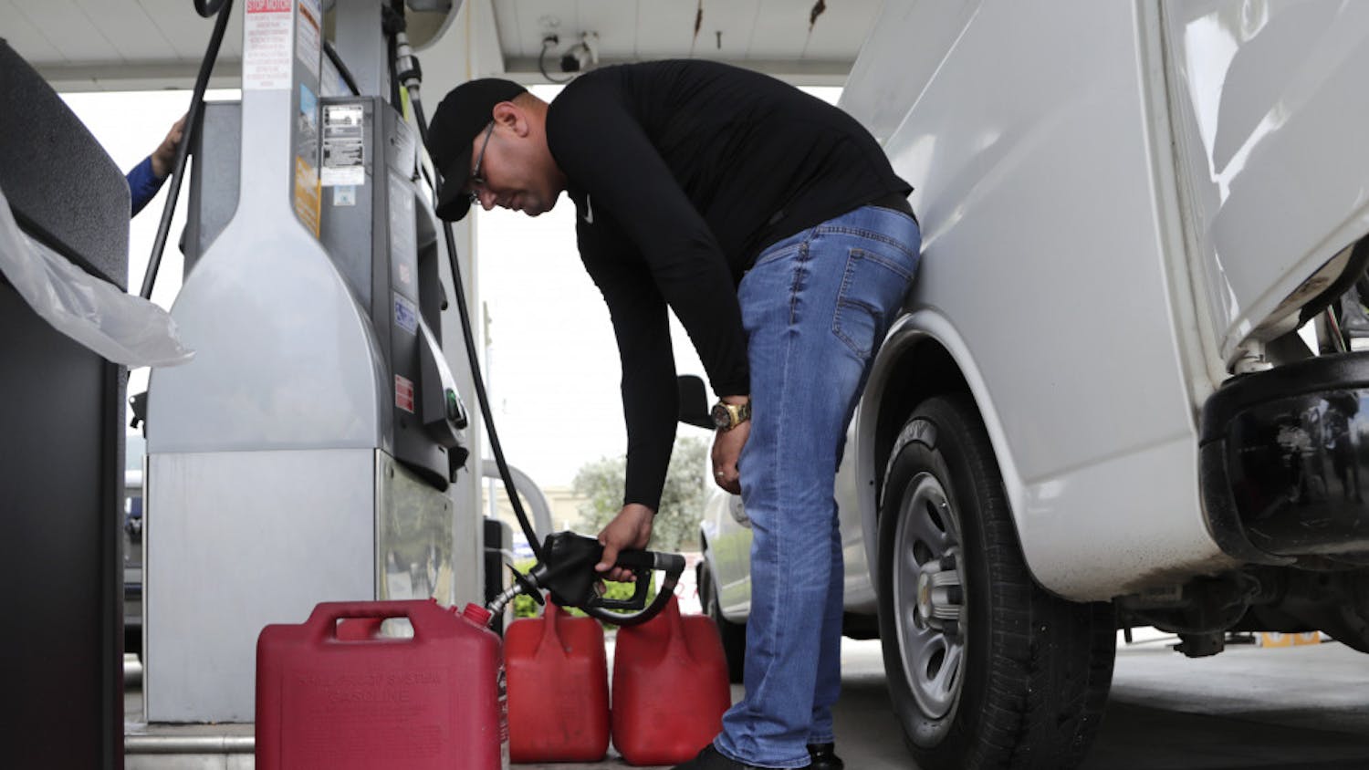 Arian Britto fills containers with gasoline at BJ's Wholesale Club in preparation for Hurricane Dorian, Thursday, Aug. 29, 2019, in Hialeah, Fla. Hurricane Dorian is heading towards Florida for a possible direct hit on the state over Labor Day. (AP Photo/Lynne Sladky)