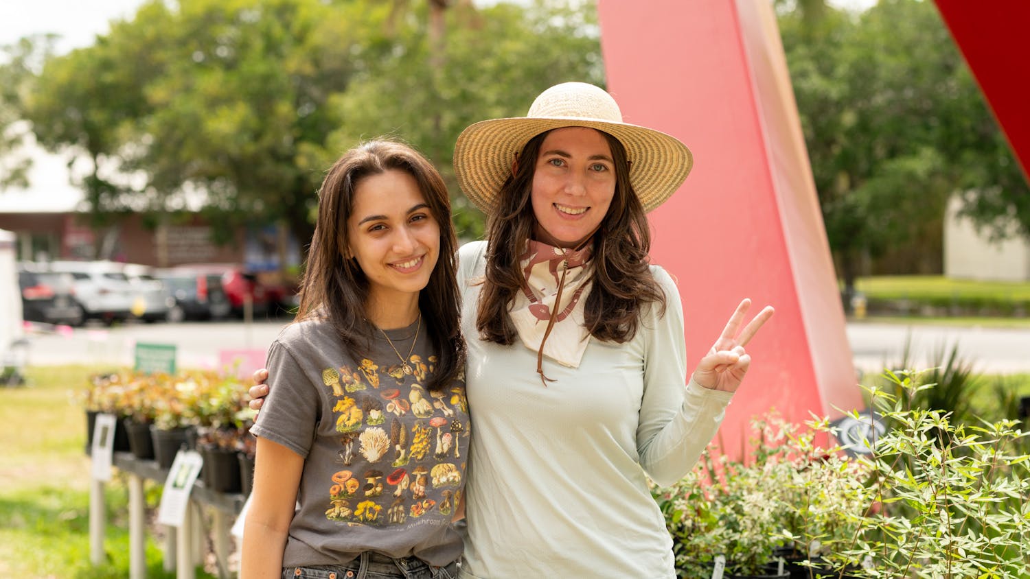 Jamielee Thompson and Sofia Ramos pictured in front of plants at the plant sale located at the Florida Museum of Natural History on Sunday, April 21, 2024.